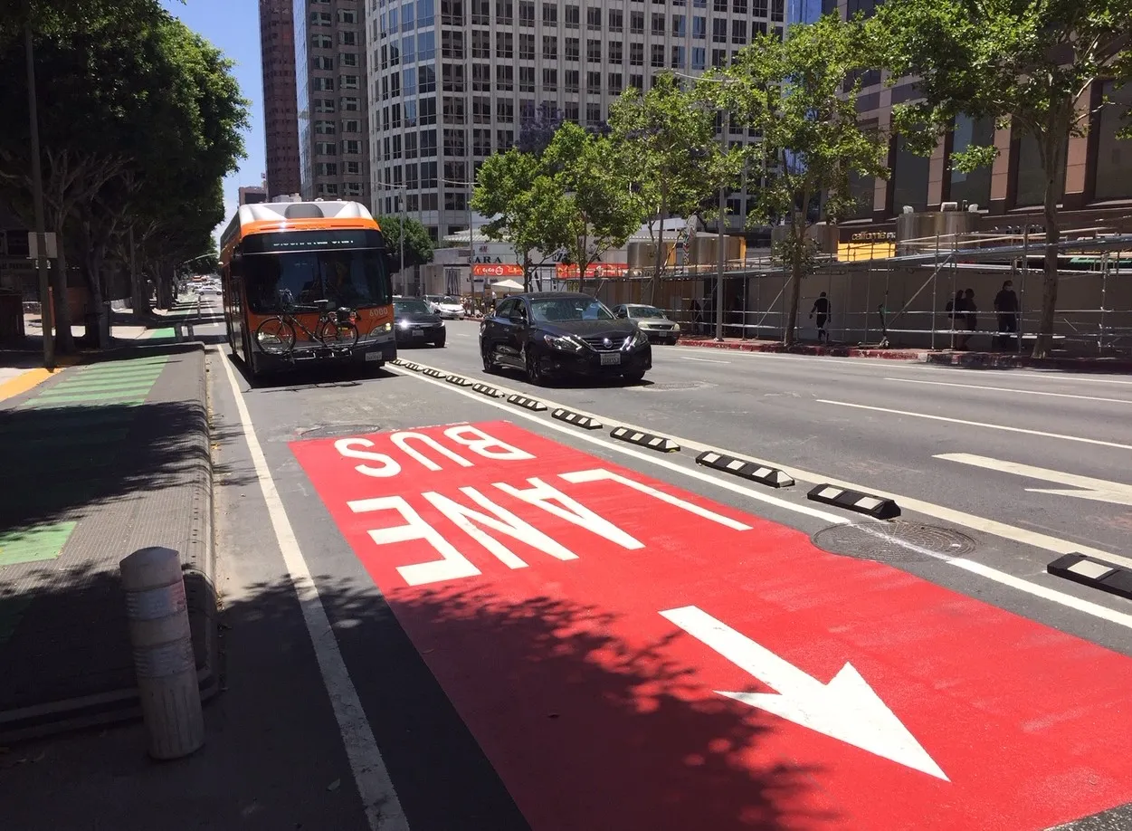 Image of an LA Metro bus in a bright red bus lane in Downtown Los Angeles.